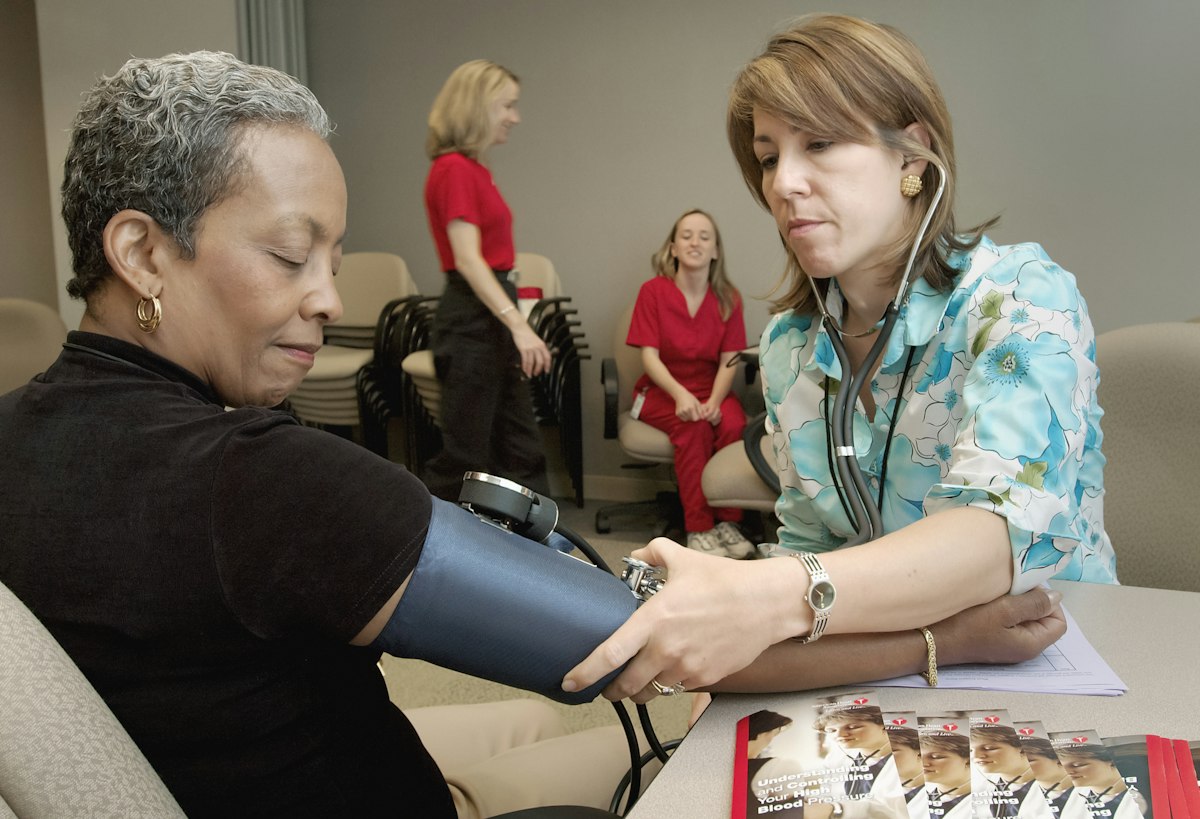 Caregiver checking a patient's blood pressure